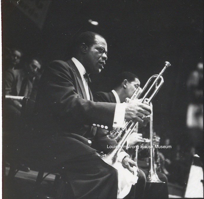 Louis taking a break while featuring one of the All Stars (possibly Edmond Hall on “Dardanella,” heard on “Ambassador Satch”)