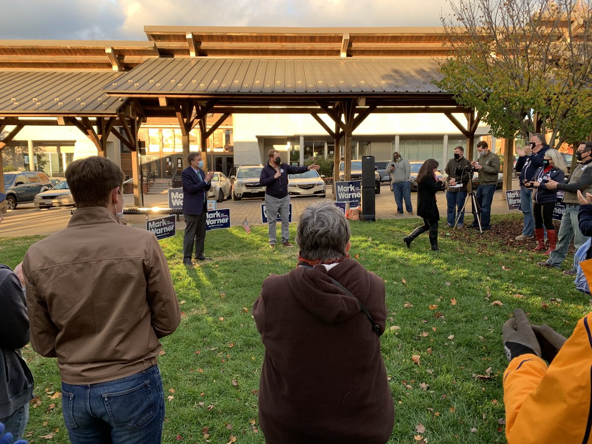 People gather outdoors, wearing face masks.