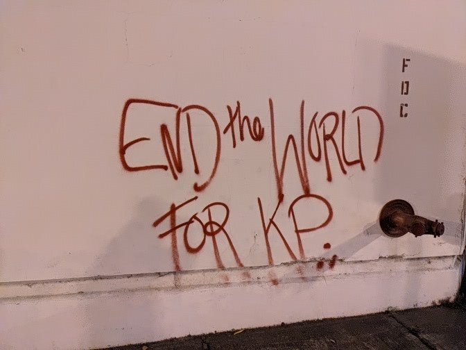 "End the world for KP" spray painted on a wall.