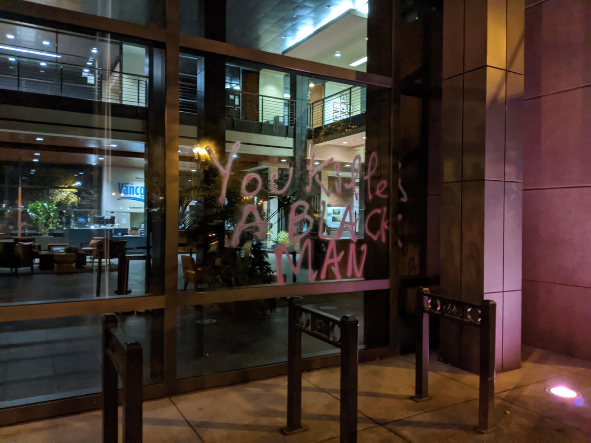 A window with "you killed a Black man" spray painted on it with