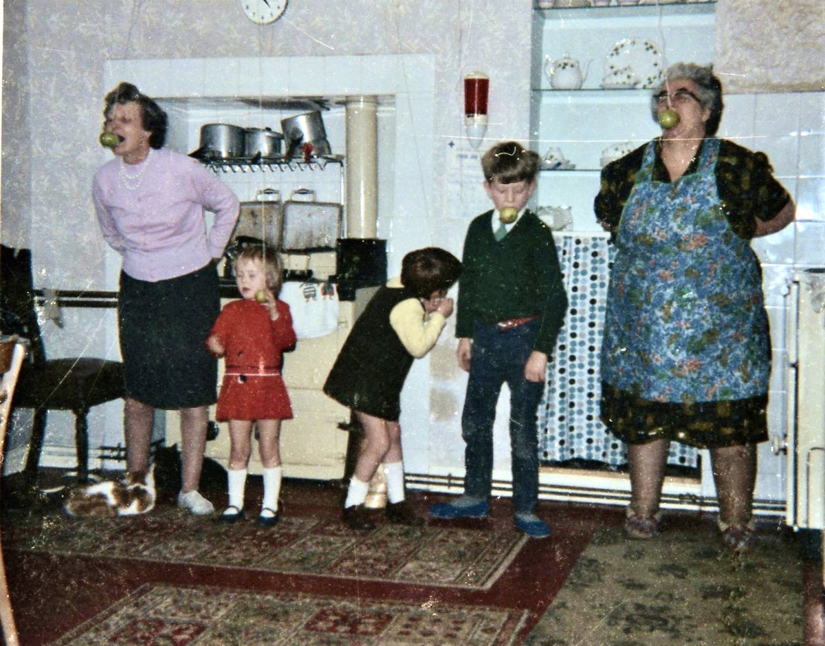 KayeWelfare's tweet photo. This is how we did Halloween in Wales 🏴󠁧󠁢󠁷󠁬󠁳󠁿 in the 1960s! Apples on strings with 2 grannies. I’m the one cheating in the middle! https://t.co/igoyYCnA3Q