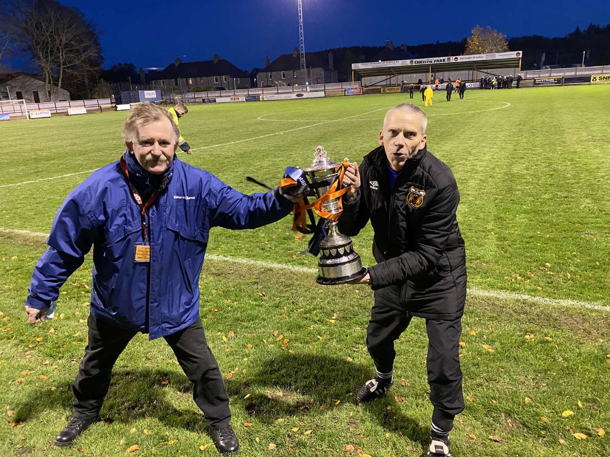 1davethesave's tweet photo. So chuffed for Rothes physio @brian_neish who has been at @RothesFC for decades and this is his first trophy! Pic of Neishy and myself observing social distancing with the famous old trophy after the final whistle @Guinness_Alan @DArcybrigodon @CaroleInnes0 @FitbaGeek https://t.co/rCK0yEhaky