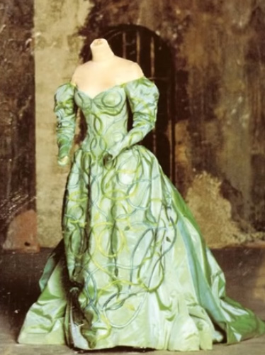 Now Lucy's in her green evening dress, but it's all snakes and seduction. Still bustled, rather than the bell shaped skirts in fashion at the time. But - her hair is UPPPPP!!!