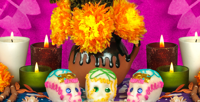 A Day of the Dead altar with candles, sugar skulls and flowers