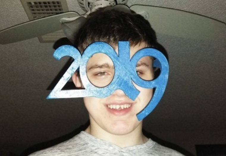 Young man wearing 2019 novelty glasses