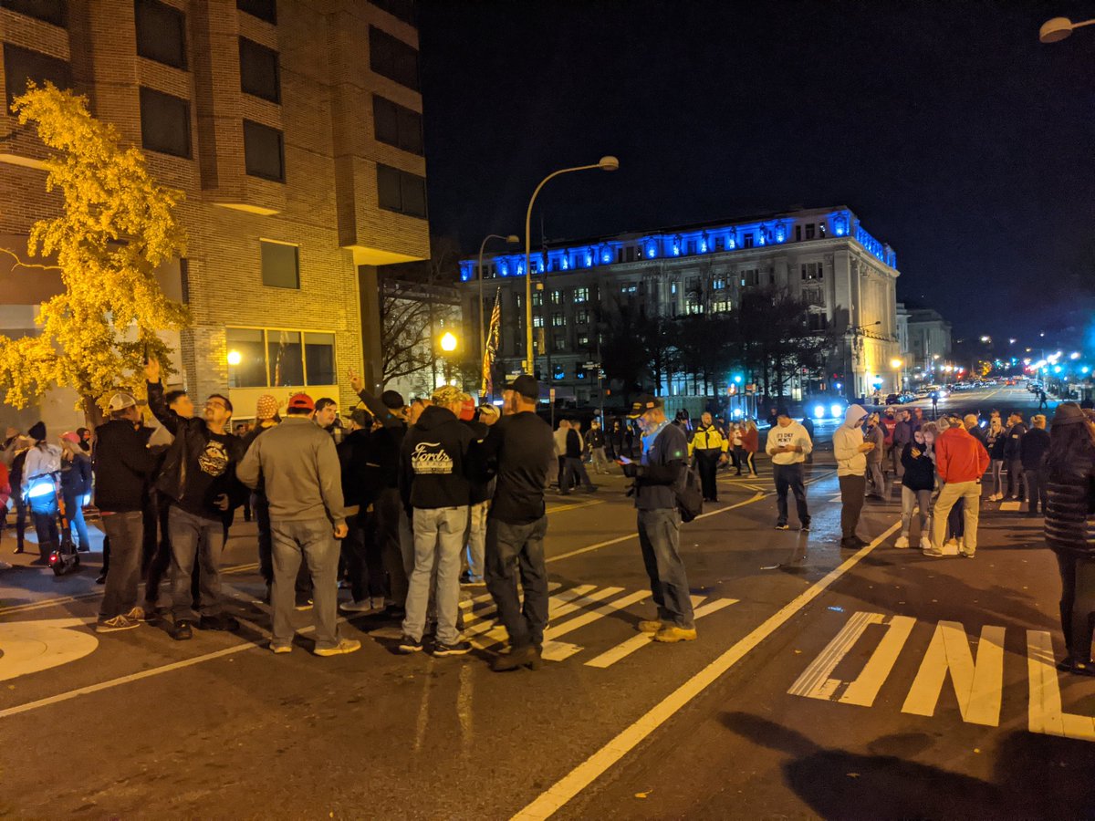 I arrive at a small group of Trump supporters hanging out outside a hotel. In the distance, two large groups of cops wait in the shadows