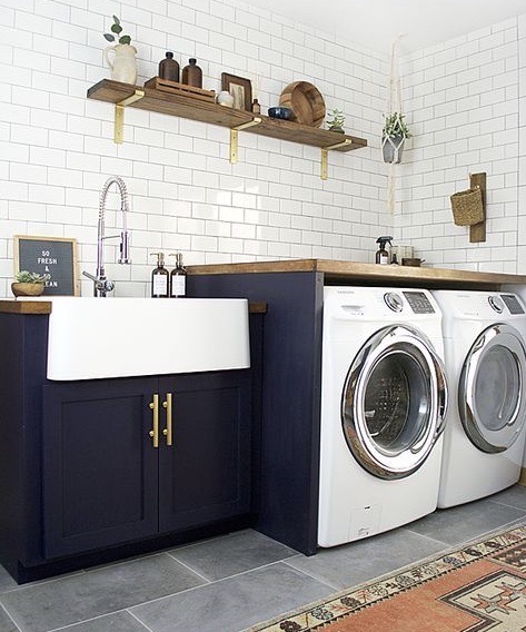 The dark blue cabinetry really makes this gold hardware pop in this lovely laundry room.