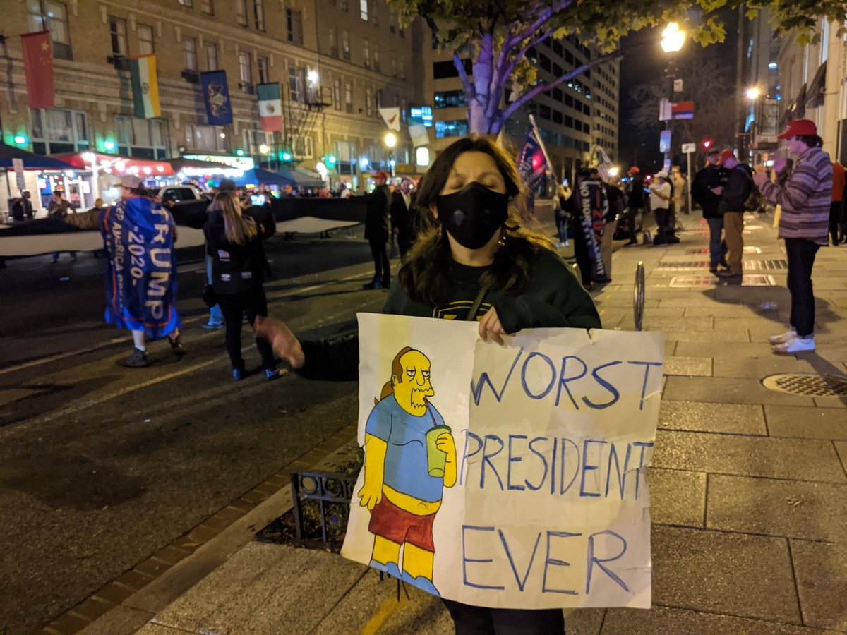 A great sign by a lone counter-protesterThe sign is ripped, and I am told that Trump supporters who did not appreciate the artistry did the ripping