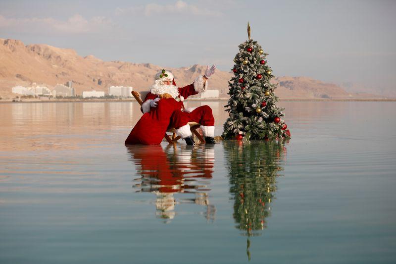 Reuters's tweet photo. Swimming Santa brings Dead Sea to life with tree and cheer https://t.co/l6Lm8apiJw https://t.co/0hXHkCvCKn