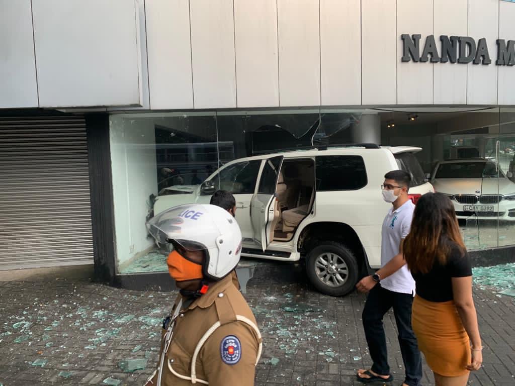 rangaba's tweet photo. A woman driver crashed a Toyota Land Cruiser into Nanda Motors, smashing the showroom and two brandnew vehicles. Errant driver is said to be a daughter of a senior police officer whose other son had killed a traffic police inspector in a hit-and-run incident in March last year. https://t.co/XVx3UBDTOp