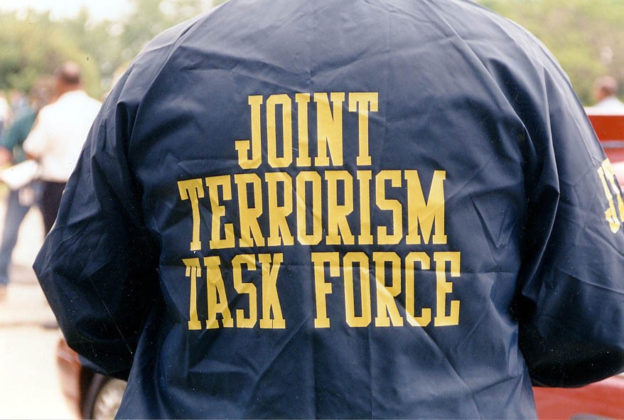 An FBI agent wears a jacket that says, "Joint Terrorism Task Force."