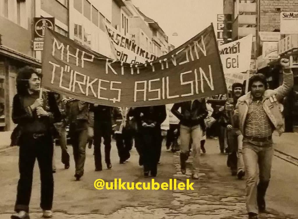 1978 yılında Almanya’da “MHP Kapatılsın, Türkeş Asılsın” afişi taşıyan marjinal sol örgüt mensupları. 
Ne kapatabildiler, ne asabildiler. Dimdik ayaktayız!