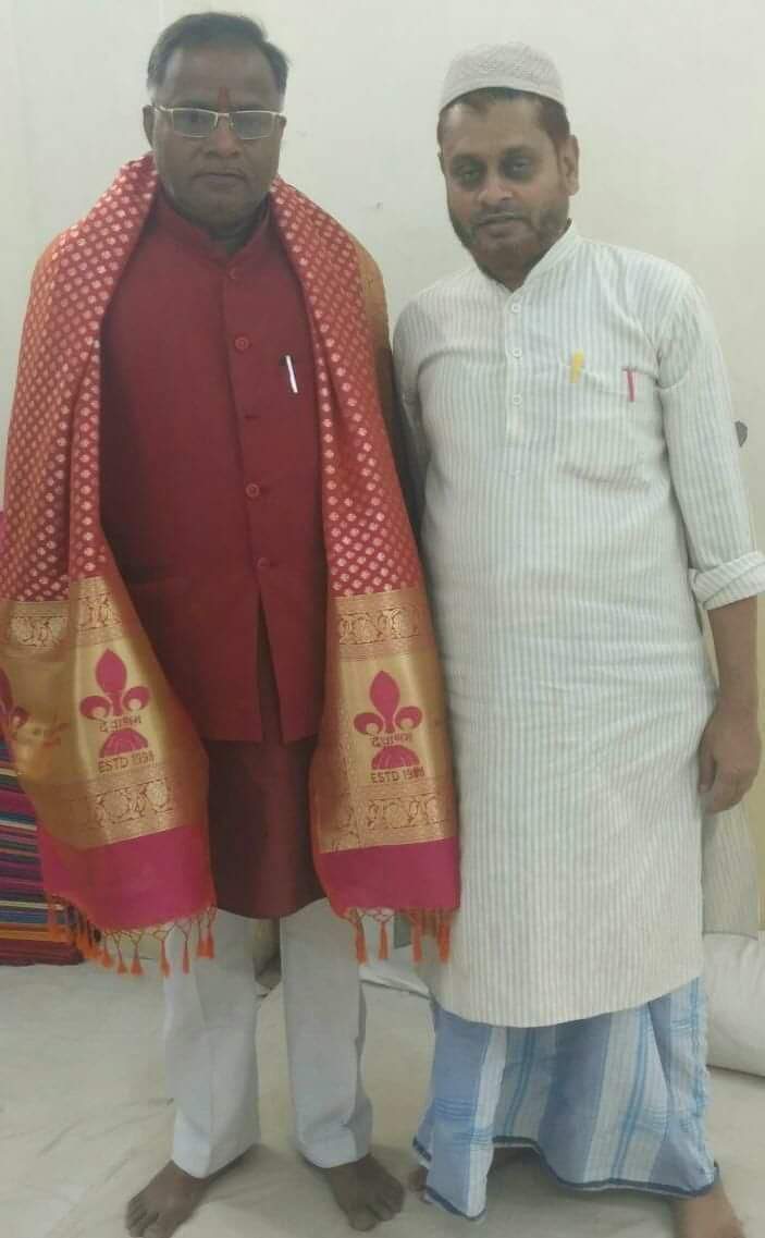 *परमपूज्य गुरु डॉ0 ब्रजनंदन जी महाराज को वाराणसी सिल्क पर विशेष कला द्वारा सामाजिक बंधुत्व एवं सद्भावना तथा गंगा जमुनी तहज़ीब का संदेश देते प्रतीक चिन्ह (लोगो) हस्त कढाईकृत अंगवस्त्रम (शाल) भेंट करते प्रख्यात मेसर्स जे जे टेक्सटाइल्स, वाराणसी के अधिष्ठाता मो0 हबीब्बुर रहमान।*