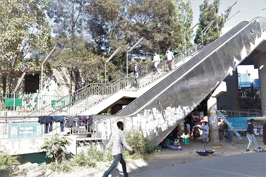 addis_fortune's tweet photo. Aimless Esclator: Not all of the parts of the #AddisAbaba LR are serving their intended purposes. This escalator in #Mesqel Square that leads to the overpass railway line does not work, but it is functioning as a place to hang wet clothes. Beneath it sits a small coffee shop. https://t.co/z1SDKxjGAN
