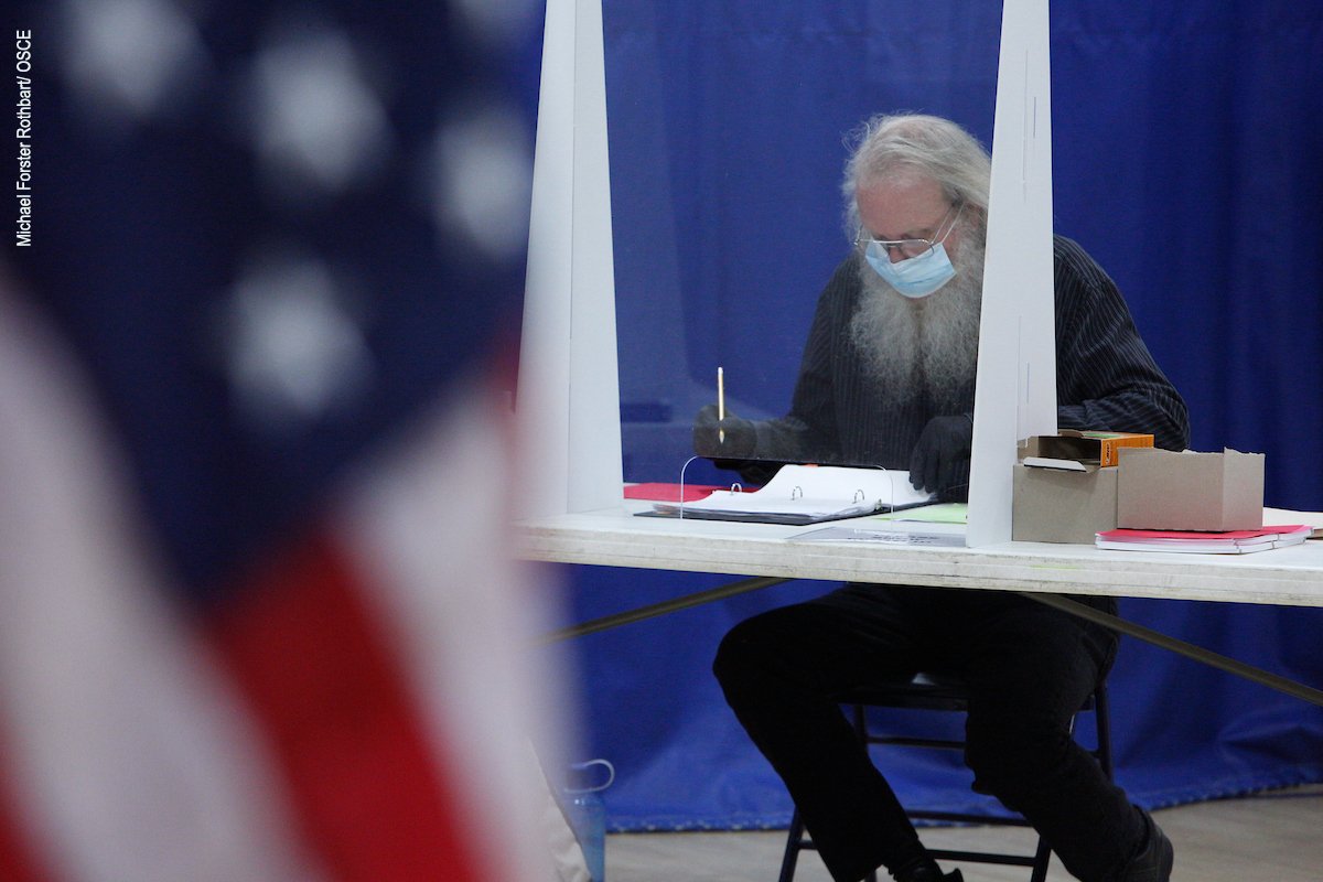 An election worker cross-checks a voter list at a polling station in Concord, NH, on election day, 3 November 2020.