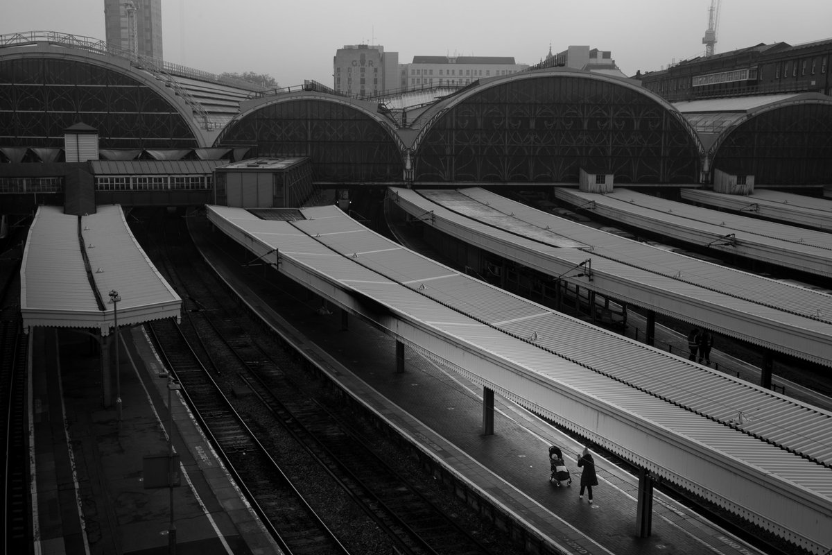 London_W4's tweet photo. Woman taking photo of baby in pram. Paddington Station. 5th November. I loved this moment as the woman photographed her child whilst she waited on an empty platform in an empty station on the first day of lockdown. Has a timeless feel, in a world where time doesn't matter anymore https://t.co/pd5hlyly85