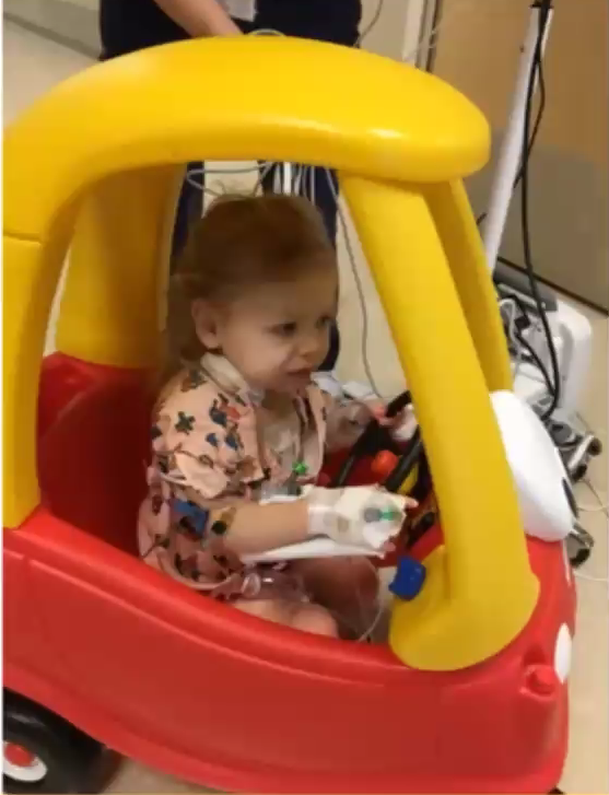 SapnaKmd's tweet photo. Hard for 2-year-old to get hyped about going for a walk POD #1 w/fresh sternotomy wound, arterial line,  2 chest bulbs to suction, IJ line &amp; tethered to an IV pole. 

Easier to get excited in a cozy coupe car. Whose idea? FAMILY. #ICURehab #PedsCICU #PedsICU

#ConsentObtained https://t.co/WglrN0PJ7F
