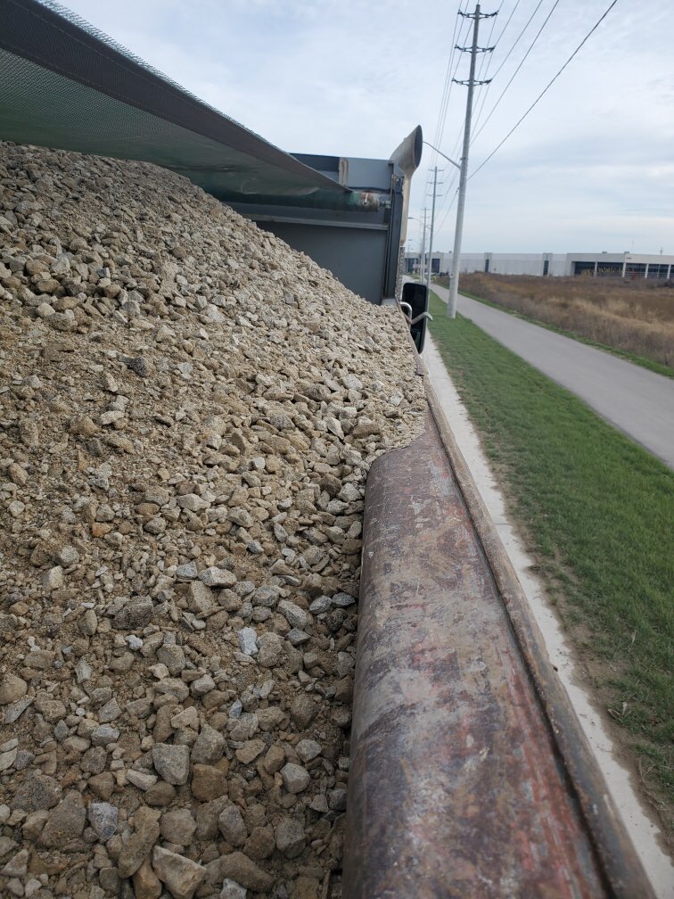 HRPSCMV's tweet photo. Investigating complaint about stones on the road witnessed this load overflowing the box and shredded load covering @HRPSMiltHH. CVSA level 1 inspection found missing suspension component... again, and improper inspection. Not #RoadSafety. Charged and out of service. ^CB https://t.co/Dp9u59SDJG