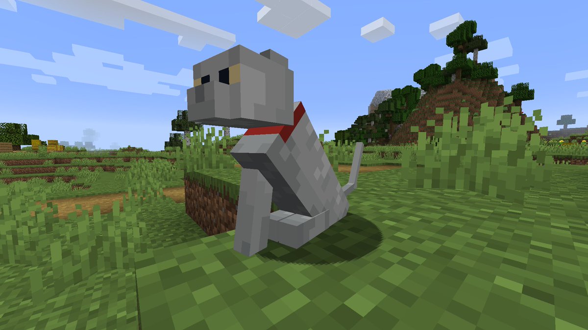 A screenshot of the game Minecraft. A white cat with a red collar sits in a grassy field. The cat appears to be missing its right left leg.