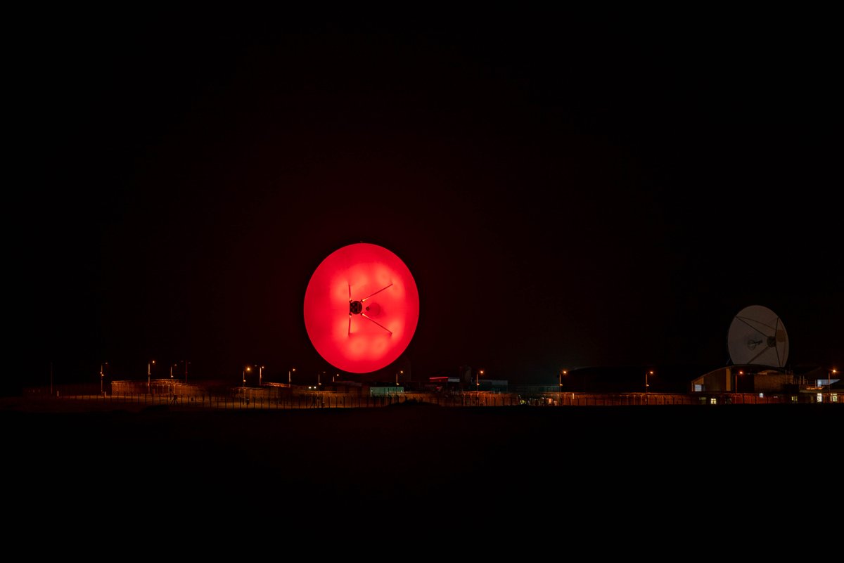 A wide shot of the Bude satellite dish lit up for the 2020 Poppy Appeal