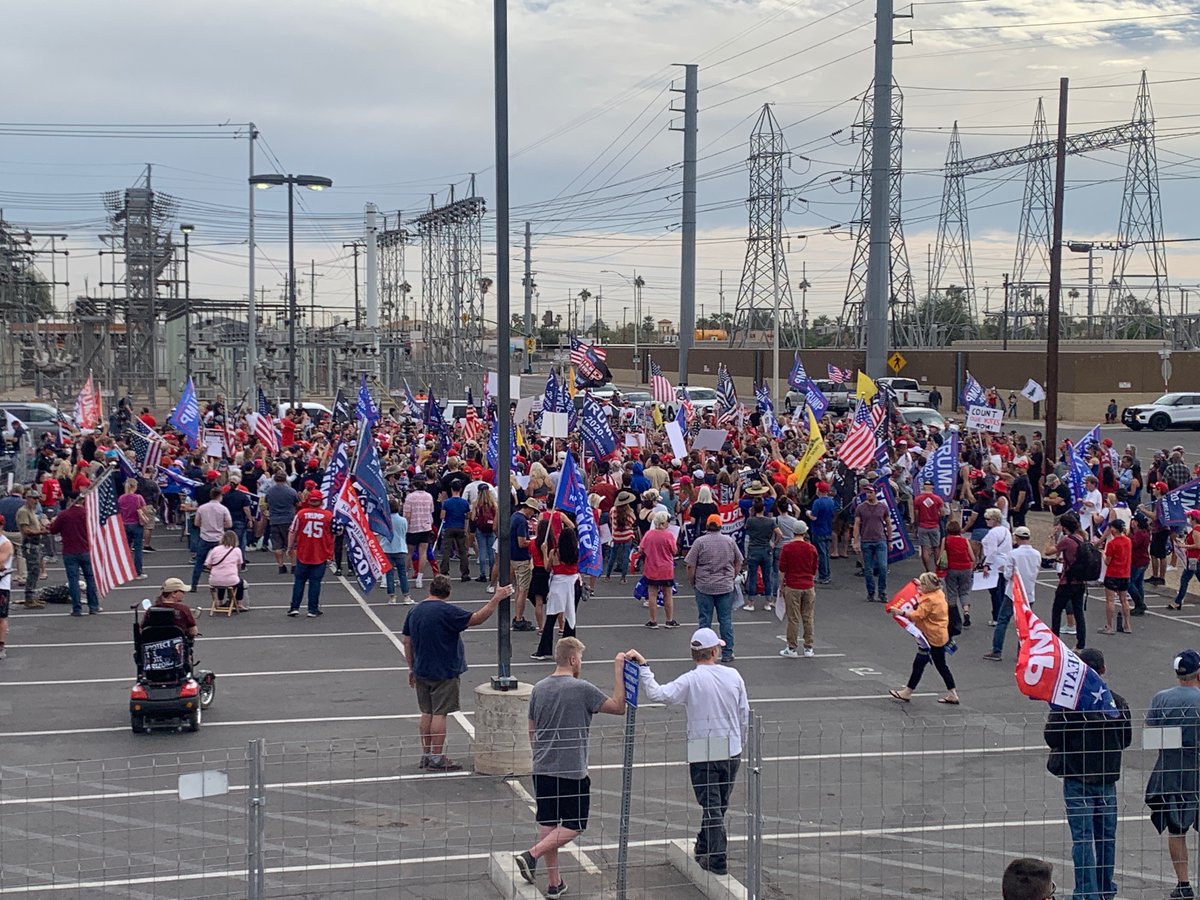 Charlie Kirk, founder of far-right campus group Turning Point USA, is speaking to the rapidly growing crowd. “This race is still very much in play in the state of Arizona,” he says.