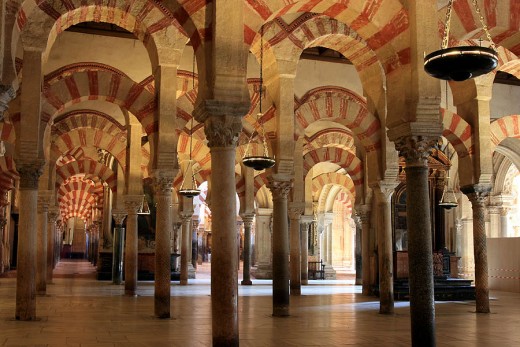 The Great Mosque of Córdoba (La Mezquita) is still one of the architectural wonders of the world in spite of later Spanish disfigurements. Its low scarlet and gold roof, jasper and and porphyry, was lit by thousands of brass and silver lamps which burned perfumed oil.