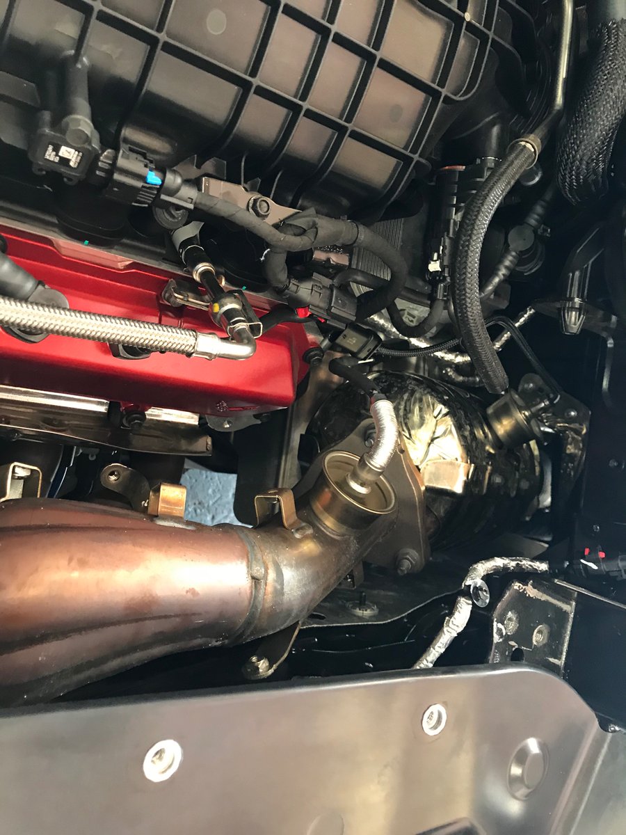 OEM headers are now visible with the heat shields out of the way. They route upwards and meander into the cat. Also pictured, the aftermarket replacements.