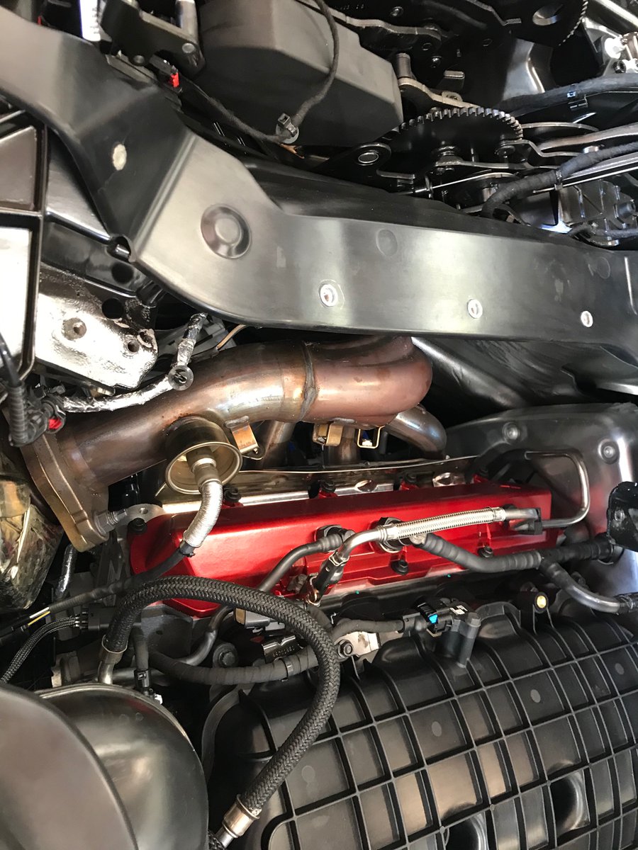 OEM headers are now visible with the heat shields out of the way. They route upwards and meander into the cat. Also pictured, the aftermarket replacements.