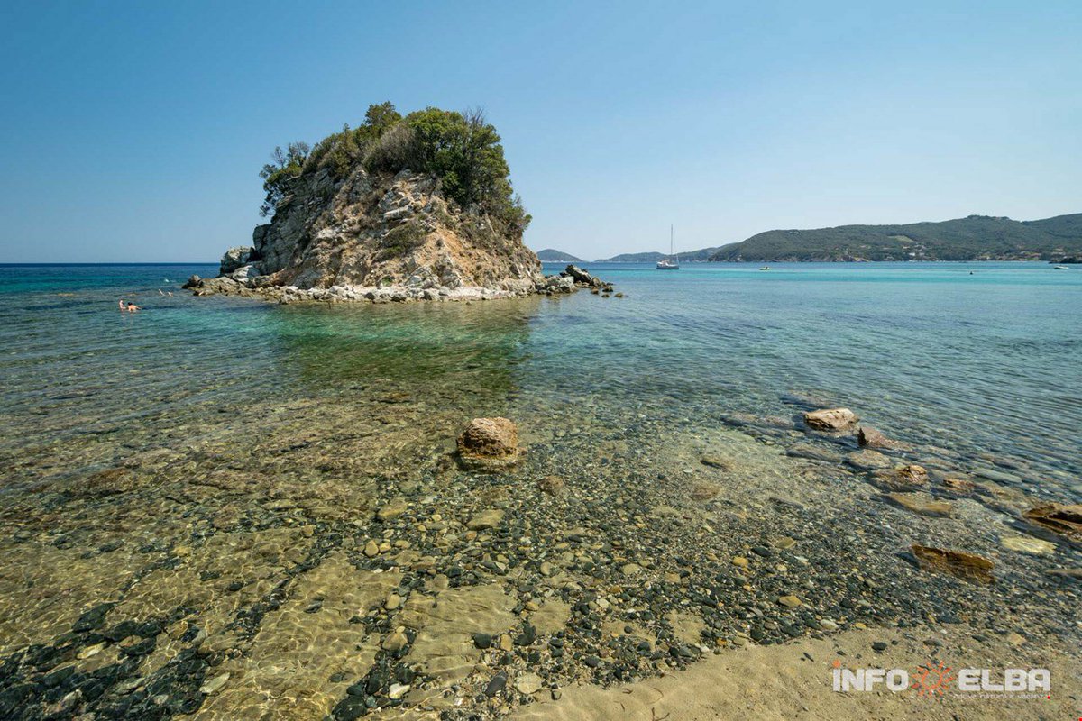 CentralElba's tweet photo. #LaPaolinabeach in Marciana is a sand and tiny stone beach. It takes its name from the tiny island on the left hand side, a few metres from the shore and  for the legend of #NapoleonSister ! According to which she used to love sunbathing on the rock. 🐚☀️ https://t.co/7hDhszF1HJ