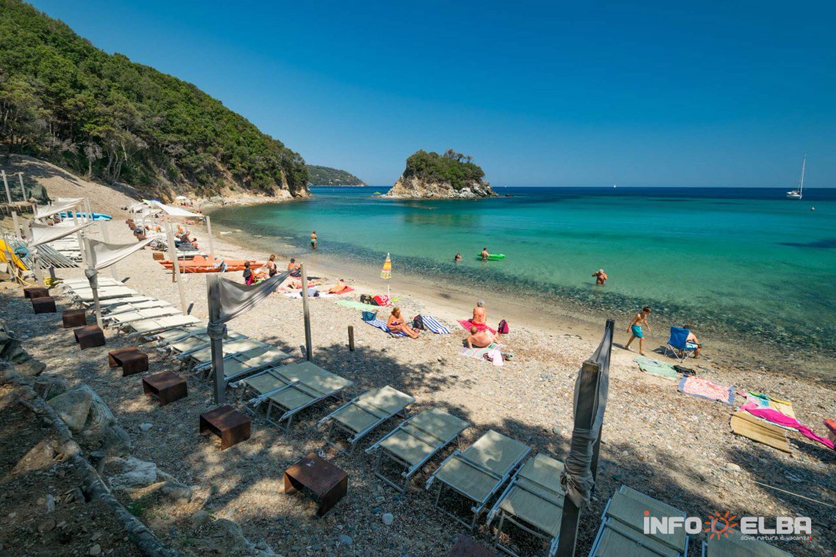 CentralElba's tweet photo. #LaPaolinabeach in Marciana is a sand and tiny stone beach. It takes its name from the tiny island on the left hand side, a few metres from the shore and  for the legend of #NapoleonSister ! According to which she used to love sunbathing on the rock. 🐚☀️ https://t.co/7hDhszF1HJ
