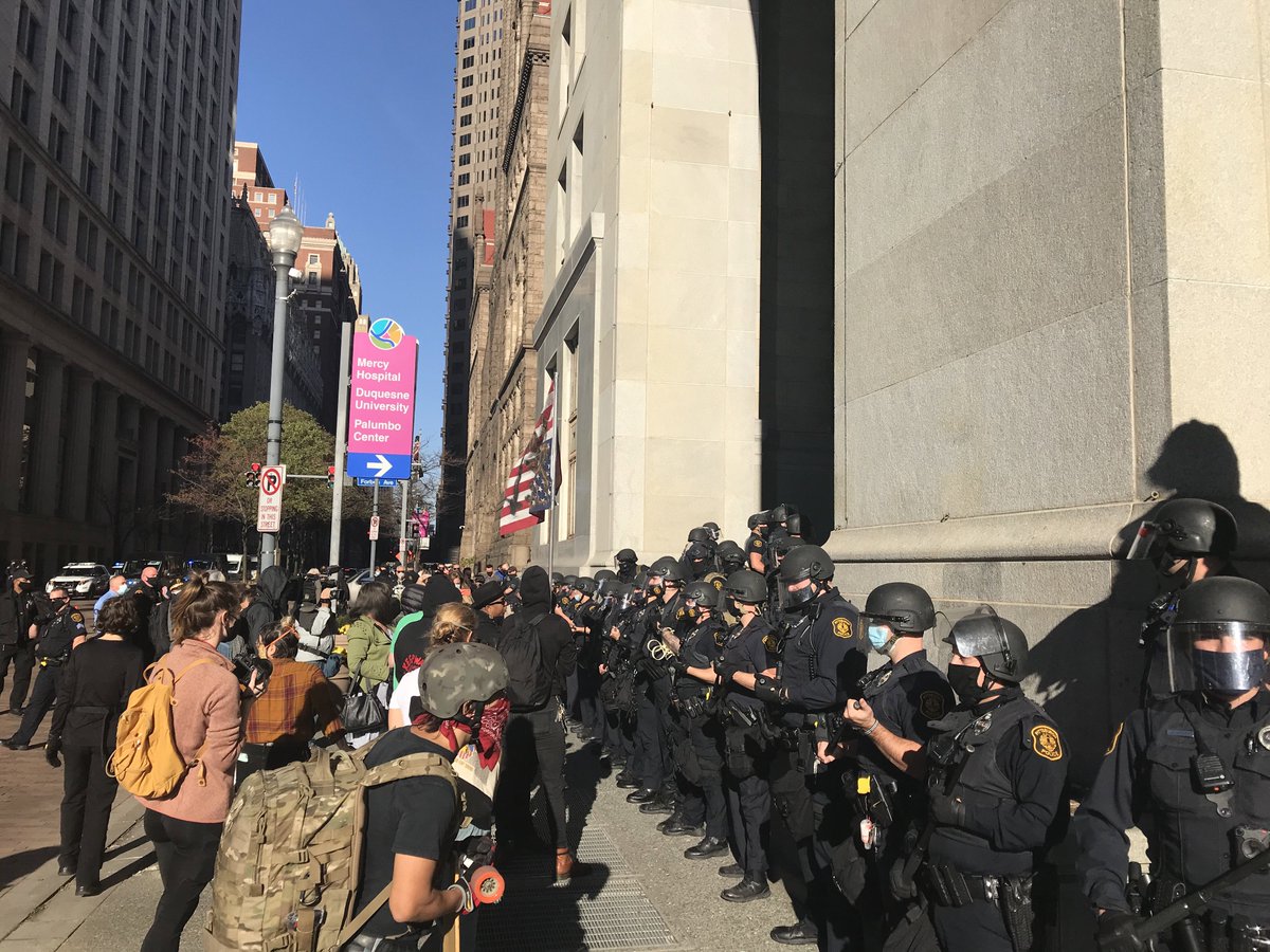After 15 minutes of opposing sides yelling at each other, police in riot gear get in-between and then force out everyone from sidewalk. Counter protesters in street. Pro-trump crowd in portico. DeVito left before this happened.