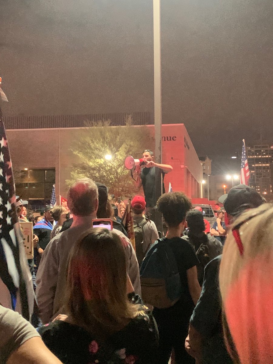 This guy asking listeners to tell everyone they know to come to the elections center. Leads the crowd in a chant of “count the legal votes! We are watching you!”