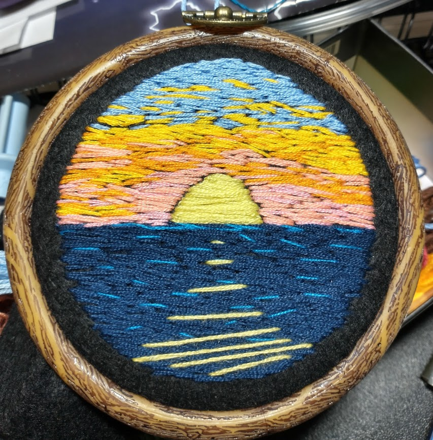 A week later, sunset over water. I should probably get myself a pen that can draw on black fabric, because I would be able to do nice circular suns that actually came out right in my sunrise and sunset images. Also unsatisfying: the reflection lines in the water.