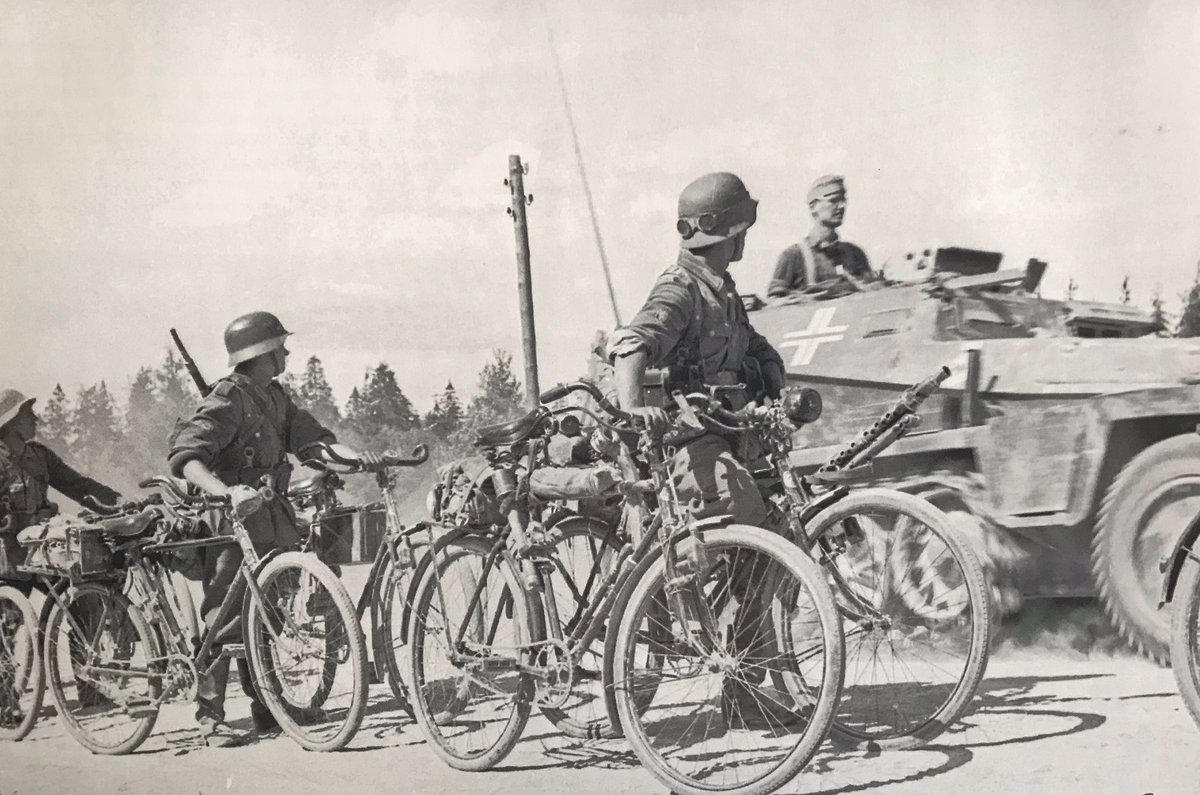 Bicycle mounted (heavy) mg34 team, somewhere in Russia 1941. The first 2 men wear Gerbirgsjäger badges. Bike front L with mg34, front R with mount for AA tripod. Middle an ammo bike, middle L a standard bicycle. They seem interested in the Sdkfz253 as it rumbles past. 38)