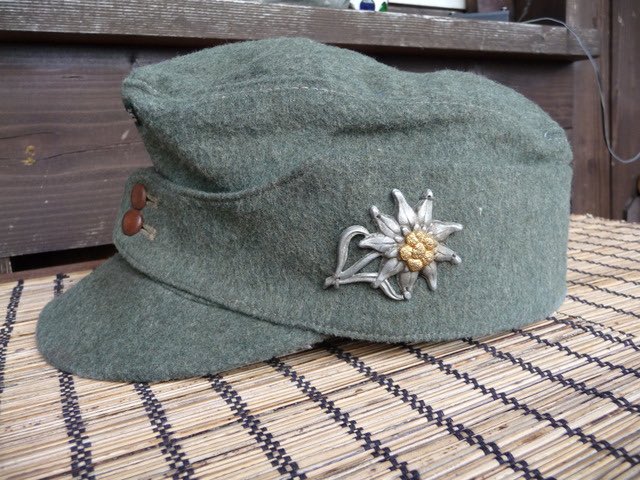 A Sdkfz253 of Sturmgeschütz Abteilung 191 in a Greek town, 1941 as men of 6th Gerbirgs Division pass by in a somewhat ragged Marschordnung formation.The Bergmütze (ski-cap) had a higher crown & shorter peak than the mid War general issue Einheitsfeldmütze.40)