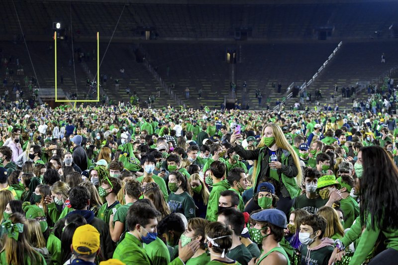 darrenrovell's tweet photo. Up above pics of Notre Dame students look insane, especially in the midst of a pandemic.

Yeah, storming the field is probably not ideal.

On the flip side, the up close shots show almost every student with a mask on.

(Photo by AP) https://t.co/e3DBo1Q969