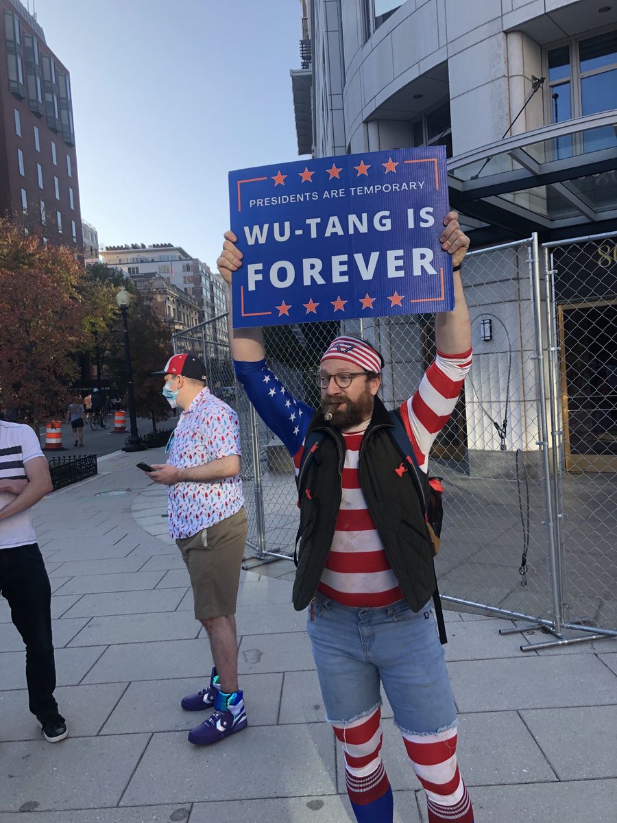 EricMGarcia's tweet photo. This dude smoking a cigar in a red, white and blue shirt and bandana with a “Presidents are Temporary, Wu-Tang is forever” sign is a vibe. https://t.co/Lo0QXkSpBW