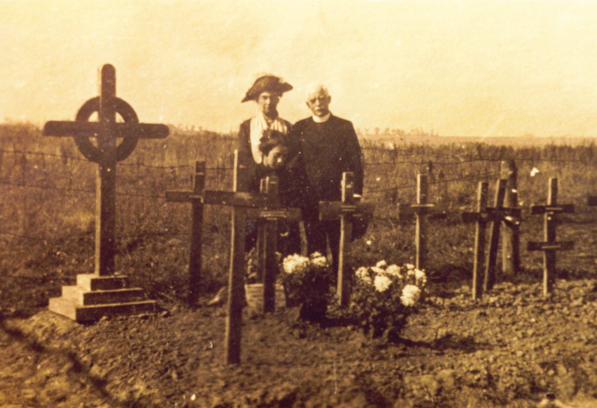 sommecourt's tweet photo. A family devastated: parents stand at their son’s grave on the Somme, a sister kneels by her brother’s cross - all they have of him now. Eric Heaton was a 20 year old officer killed in his first battle. The pain of loss, the cost of war in one photograph. #RemembranceSunday https://t.co/3rfYYOkexF