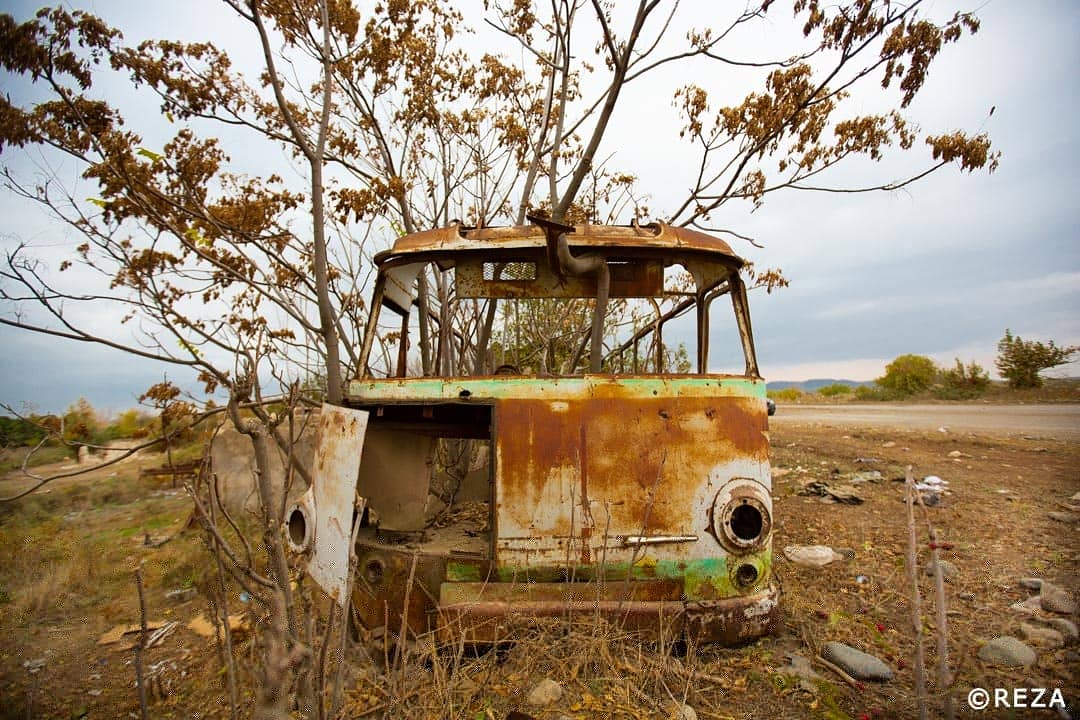 REZAphotography's tweet photo. The newly liberated town of Füzuli is a ghost town. Nature took over everything. This bus reminded me of stories of displaced in the 90s. They took buses to leave their land and were stop, robbed, assaulted and humiliated by Armenian soldiers. #Azerbaijan #Karabakh #Fuzuli https://t.co/29RqzLwlF1