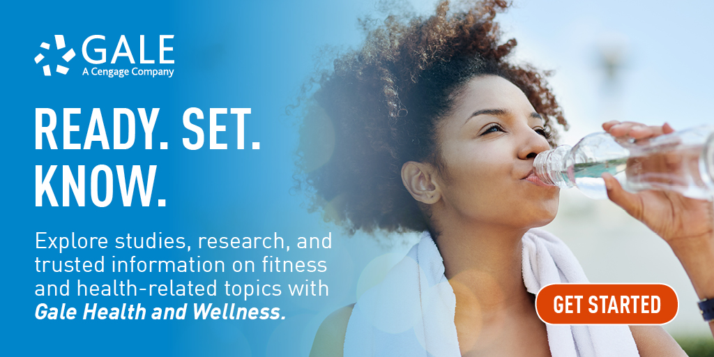 a black woman drinking a bottle of water wearing a towel around her neck