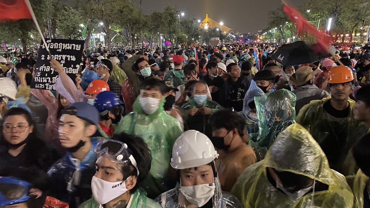 Protest organisers holding up signs while askig for people to sit down so the police don't shoot water cannons at them again. While use force at these people?  #ม็อบ8พฤศจิกา