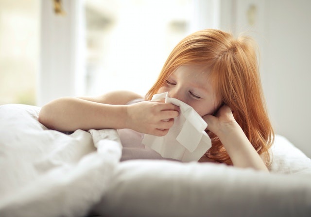 red haired girl blowing her nose
