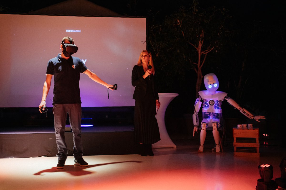 robodies's tweet photo. Telepresence! Daniel controls me as if I was his own body and figures out under which cup the coin lies. Moderator Steffi can't believe, she's about to loose that cup-game yet again, even when I was blind, when she shuffled. But there was a trick ... #roboy #humanoid #avatar https://t.co/wujFsQbAec