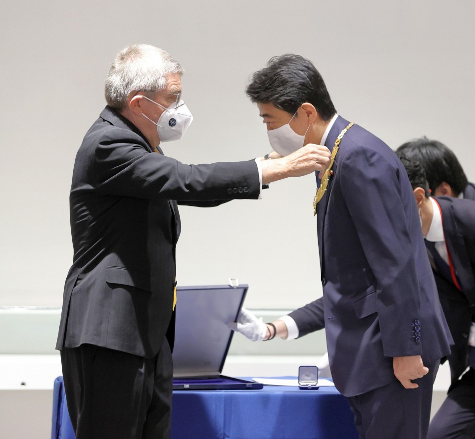 DDNewslive's tweet photo. Former Japanese Prime Minister @AbeShinzo receives the #Olympic Order from IOC chief Thomas Bach; the International Olympic Committee has expressed confidence that the Tokyo Games will be held successfully next year https://t.co/QW1yLsGkq4