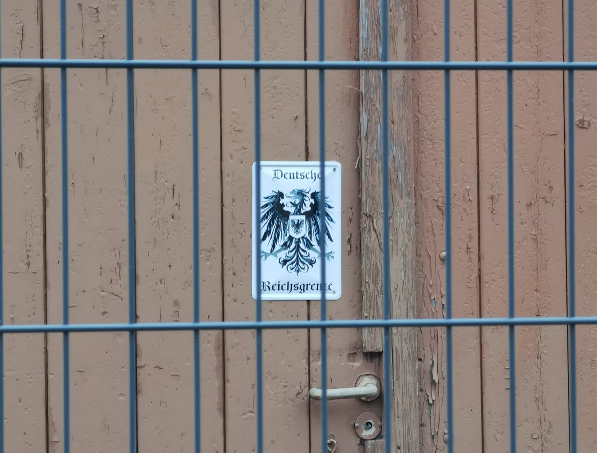 Auf einer Wanderrroute bei #Dresden. Die "Landesgrenze" ist komplett mit Bauzäunen gesichert. Am Fenster, gerade so über das Sims lugend, wacht ein Mann über das Grundstück. Und in der nahegelegen Wanderhütte haben wir dann erstmal die vielen IB-Sticker entfernt. #Reichsbürger