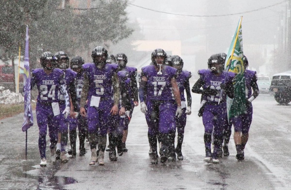 Badass 📸 

The Mullan, Idaho and St. Regis, Montana <a href="/Idaho_8_Man/">Idaho8Man</a> football co-op struts down the street on its way to John Drager Field for a snowy playoff game.

Mullan flag on left, St. Regis flag on right, representing two towns and states
 
I hope they win it all #idpreps