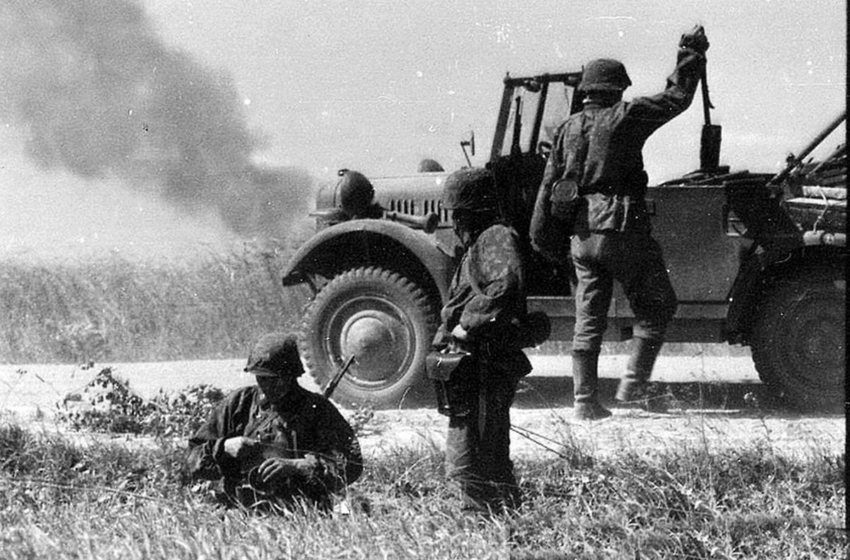 Communication established, the team start to repack their vehicle to move on, as smoke trails to their right. 47c)