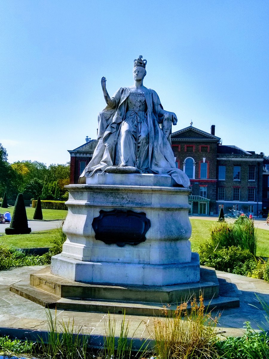 Queen Victoria outside Kensington Palace, her childhood home - where, aged just 18, she woke up to the news that her uncle had died. Sculpted by her fourth daughter Princess Louise and erected in 1893. It depicts Victoria aged 18, seated in her coronation robes.  #womenstatues