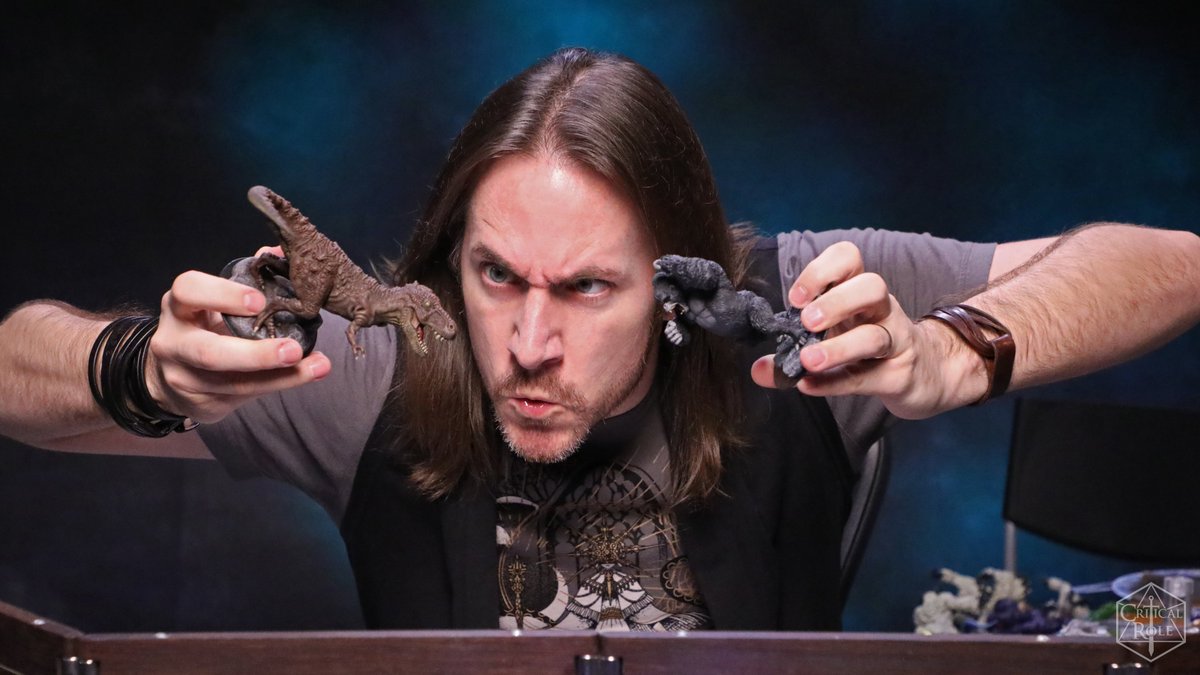 2020. Matthew Mercer makes a very silly face while playing with a T-Rex and...