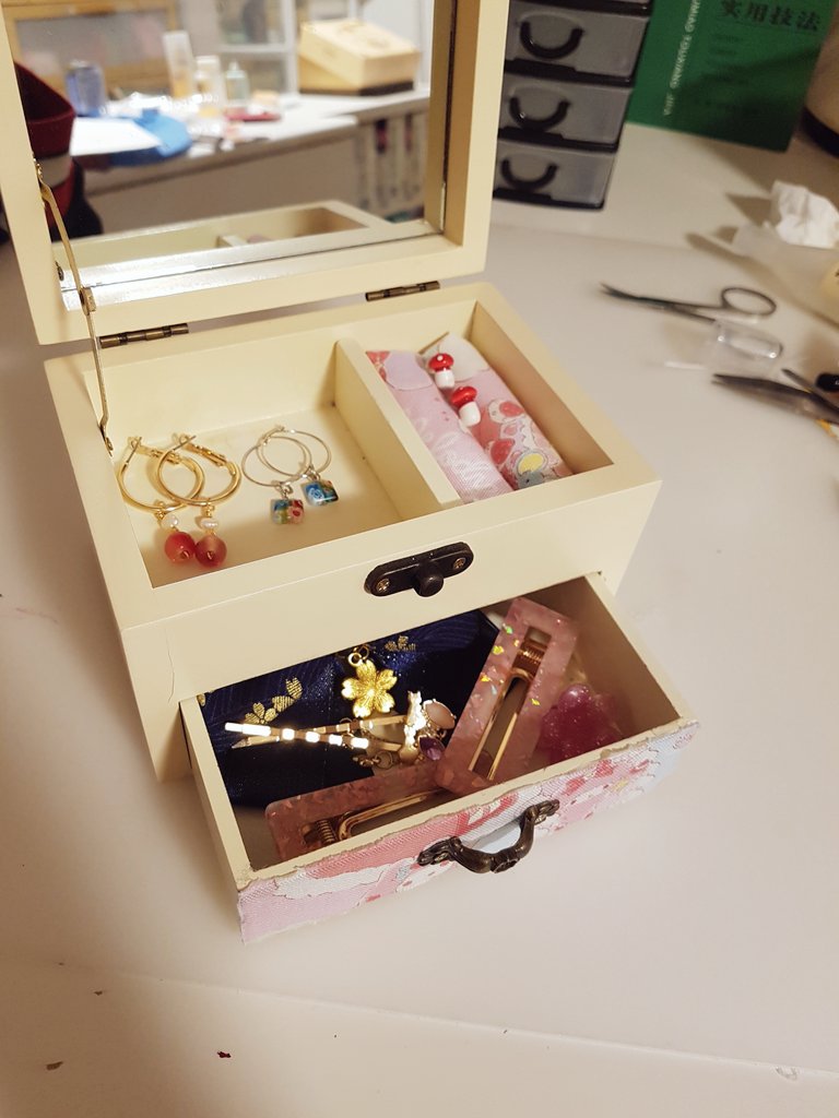 The box and drawer are now open to reveal various jewellery and small hair accessories such as clips and bows